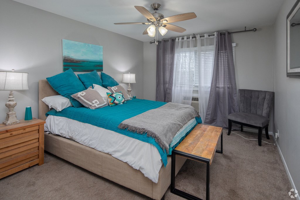 a bedroom with a bed and a ceiling fan