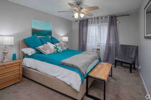 a bedroom with a bed and a ceiling fan