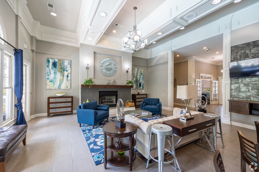 a living room with a fireplace and a table and chairs  at Flats at North Springs, Georgia, 30328