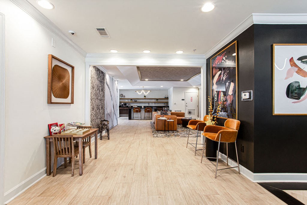 the lobby of a hotel with tables and chairs and a bar at Indigo Apartments Gainesville, Gainesville Georgia