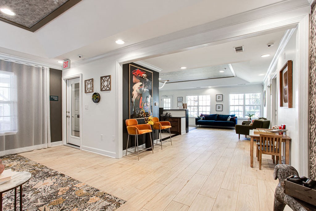 the living room and dining room of a house with white walls and wood floors at Indigo Apartments Gainesville, Gainesville, 30504
