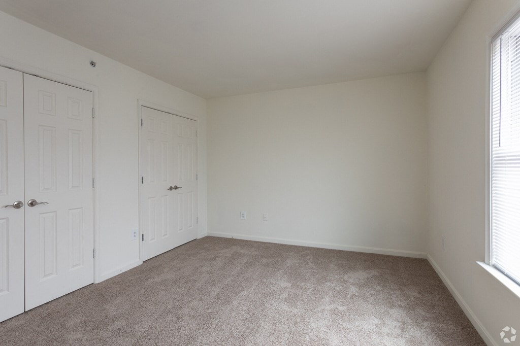 a bedroom with a carpeted floor and a white door