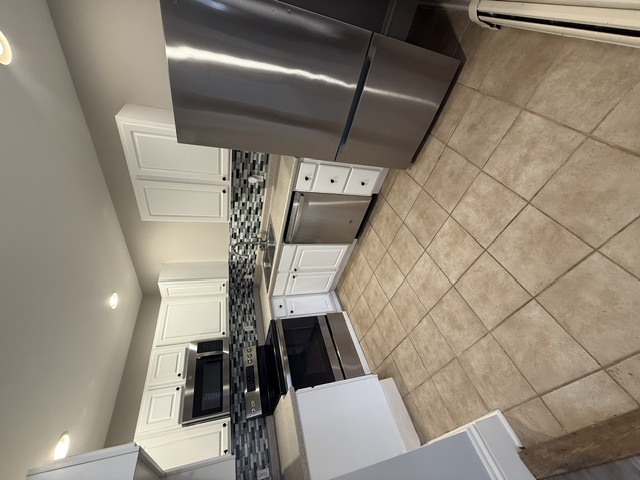 A stainless steel refrigerator is installed in a kitchen.