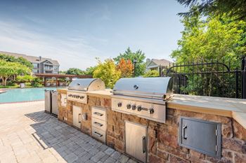 a large outdoor kitchen with a pool in the background at Lex at Brier Creek in Morrisville, North Carolina