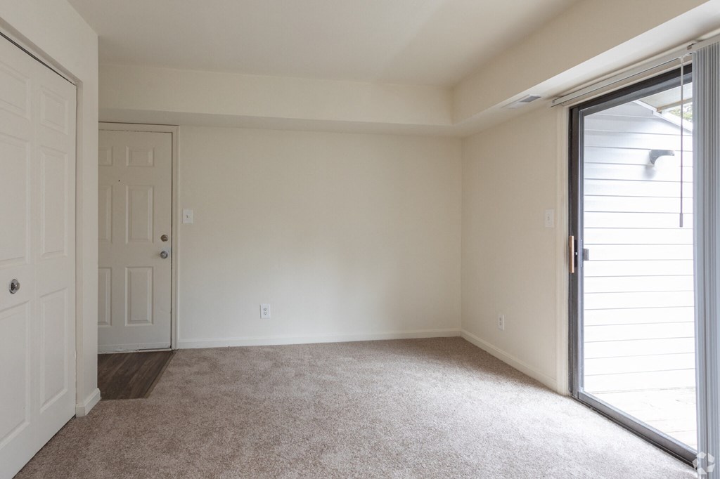 a bedroom with a sliding glass door and a carpeted floor