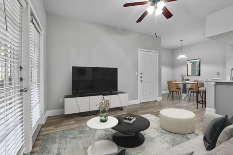 A living room with a television, a table, and chairs.