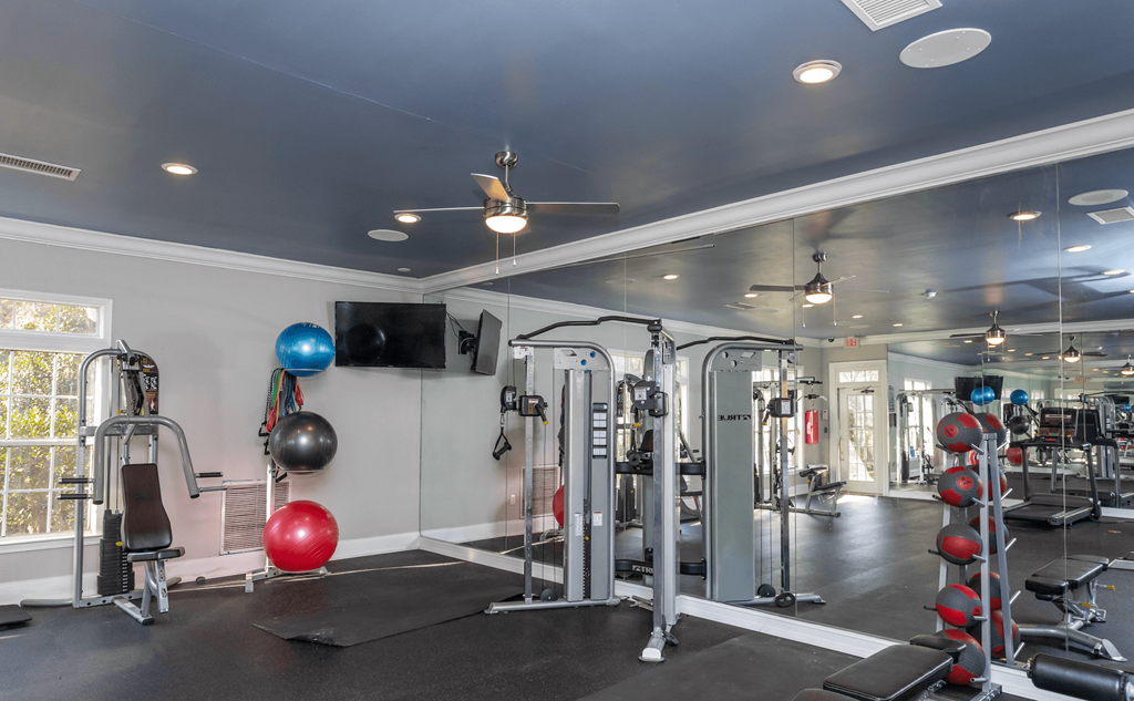 a home gym with exercise equipment and a tv on the wall