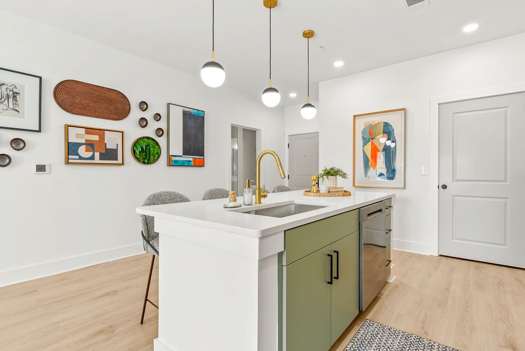 A kitchen with a white counter and green cabinets.