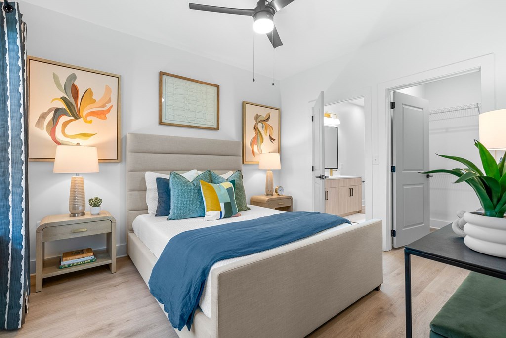 A bedroom with a bed, nightstands, and a ceiling fan.