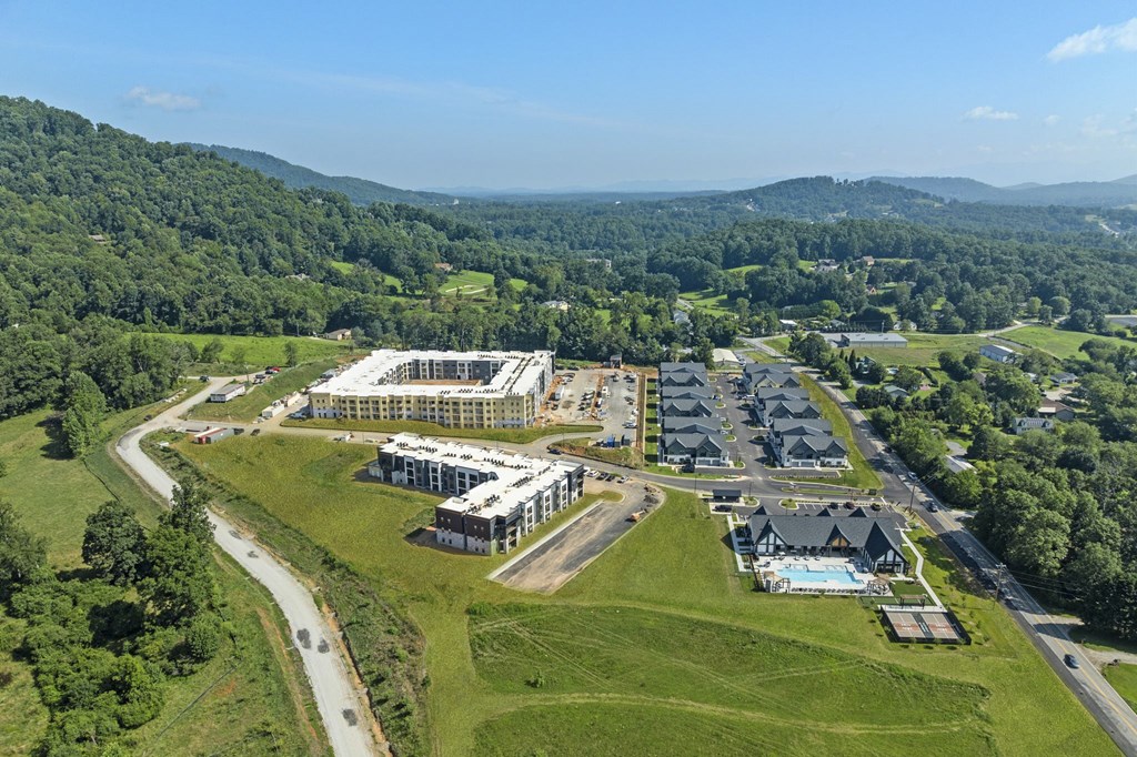 A large building complex is surrounded by a green landscape.
