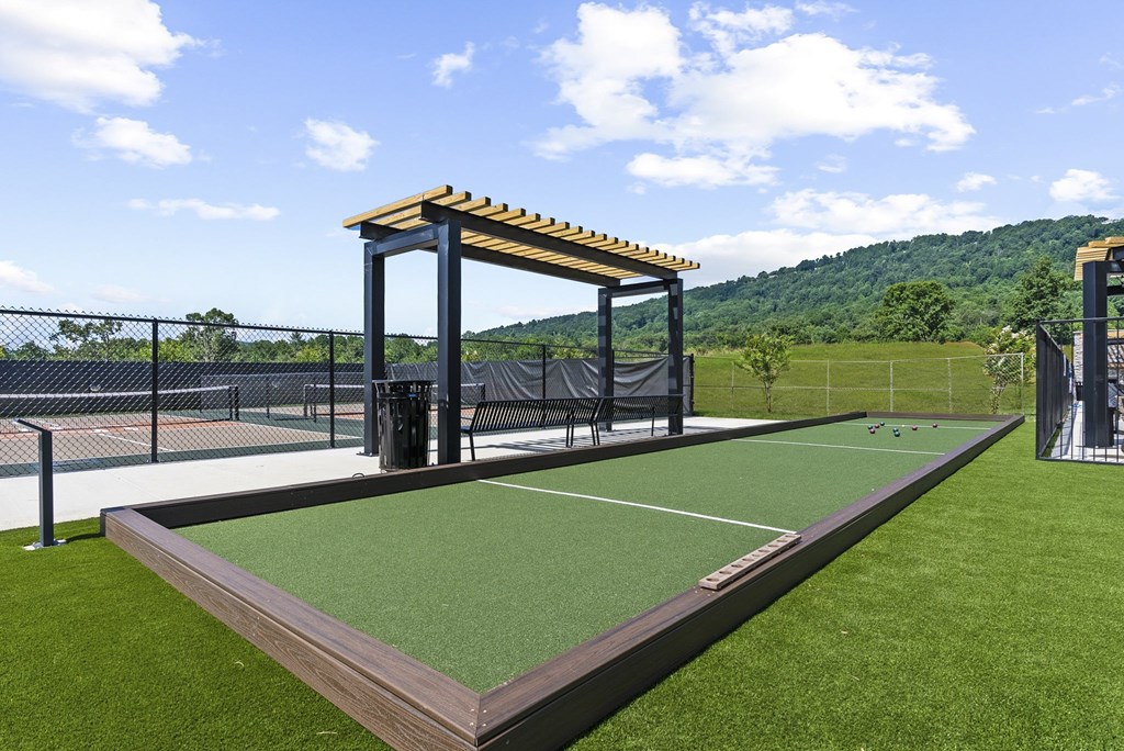 A tennis court with a wooden roofed shelter.