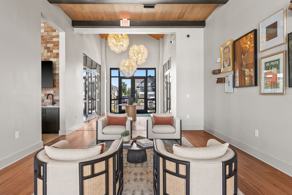 A living room with a couch, chairs, and a rug.