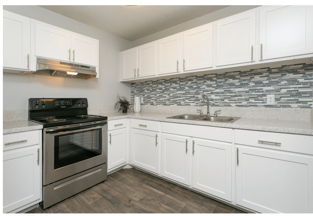 a kitchen with white cabinets and stainless steel appliances