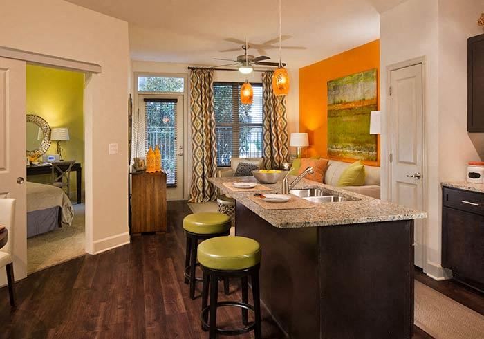 a kitchen with a counter top next to a living room - Photo Gallery