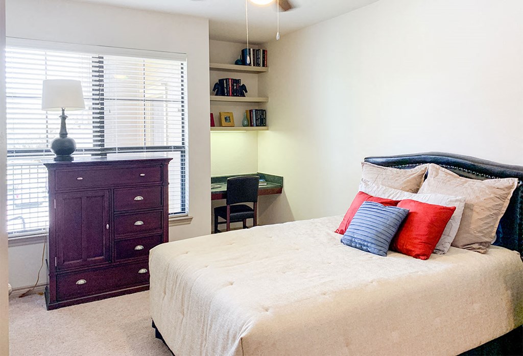 a bedroom with a bed and a dresser and a window