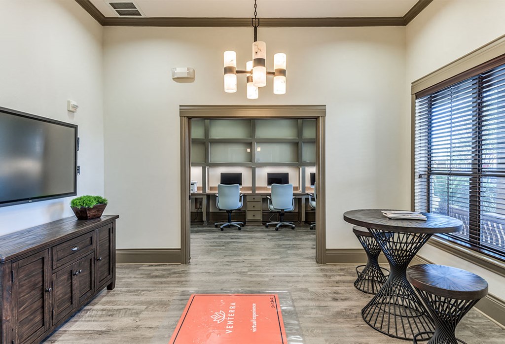 a conference room with a tv and a table with chairs