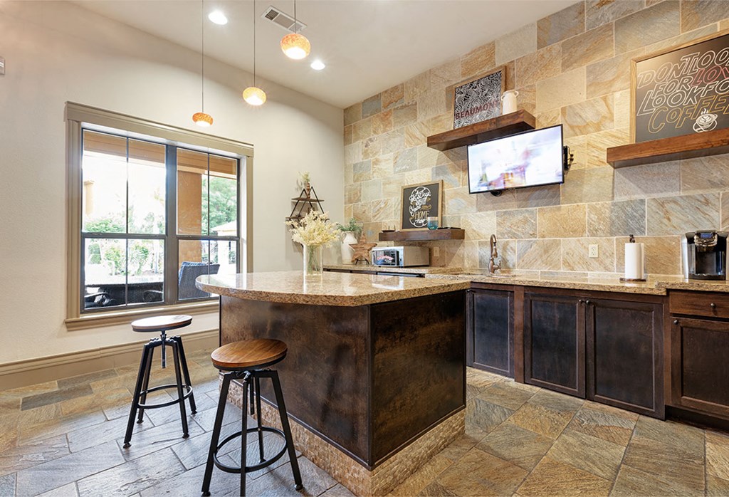 a kitchen with a bar and a tv