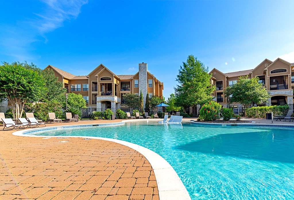 a swimming pool with an apartment building in the background