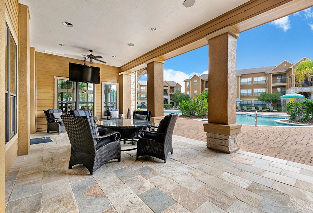 a patio with a table and chairs and a swimming pool