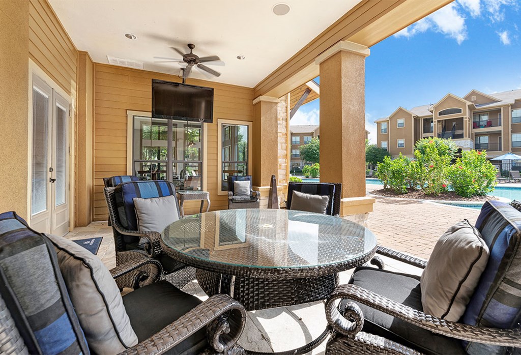 a patio with a table and chairs and a pool