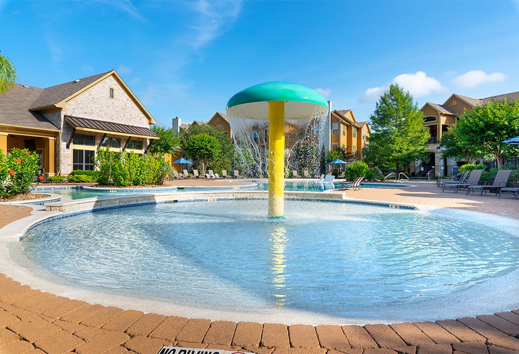 a large pool with a water fountain in the middle