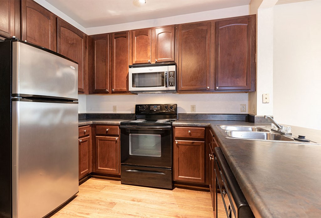 a kitchen with wooden cabinets and stainless steel appliances