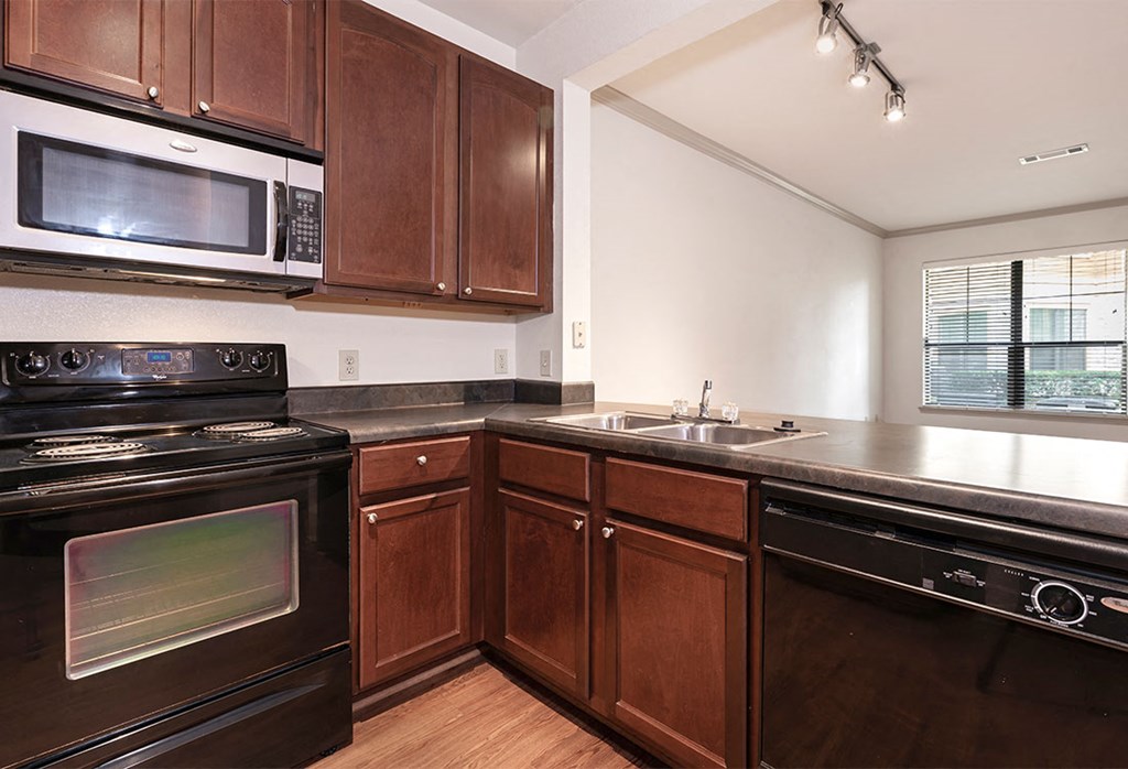 a kitchen with a sink and a stove and a microwave