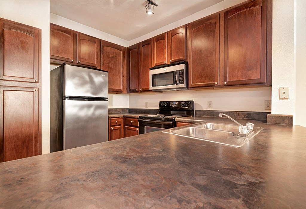 a kitchen with stainless steel appliances and wooden cabinets