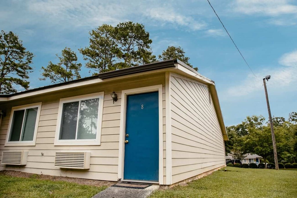 the front of a tiny house with a blue door