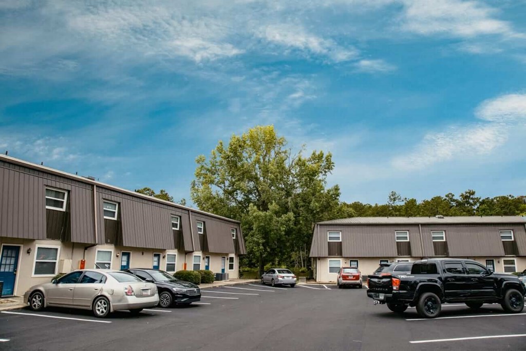 a parking lot with cars in front of an apartment building