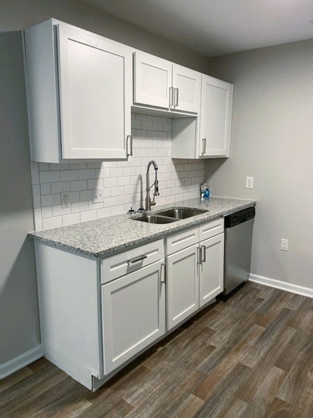 an empty kitchen with white cabinets and a sink