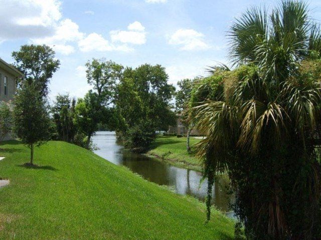 a grassy area with a river in the background at Waters Edge Apartments, Florida, 33803