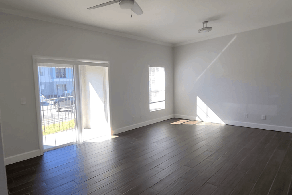a bedroom with a sliding glass door and hardwood floors a bedroom with a sliding glass door and hardwood floors at Waters Edge Apartments, Lakeland, FL