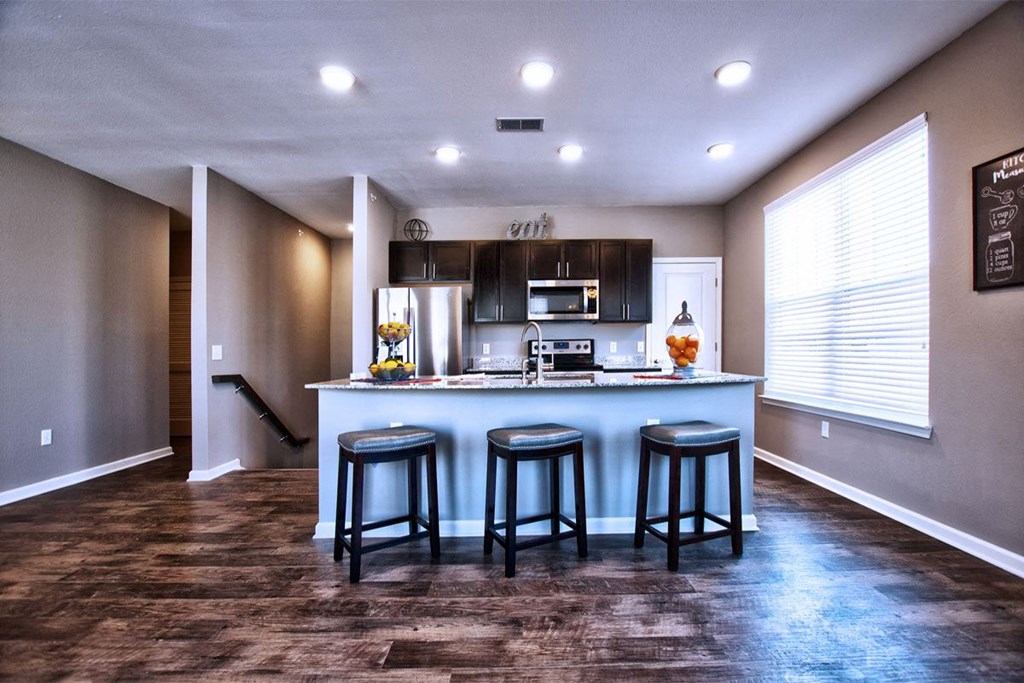 a kitchen with a large island with three stools in front of it at Park 33, Indiana