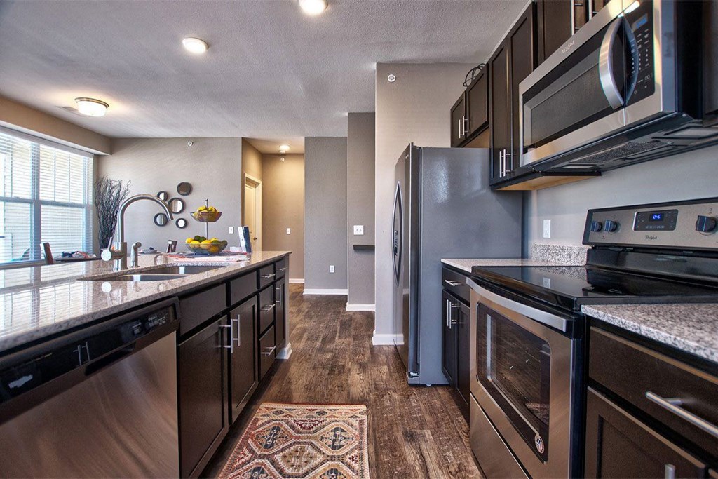 a kitchen with dark cabinets and stainless steel appliances at Park 33, Goshen Indiana