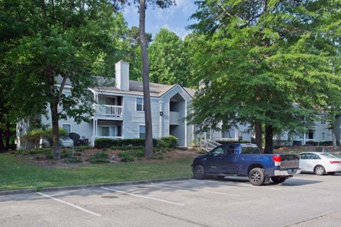 a blue truck parked in a parking lot in front of a house