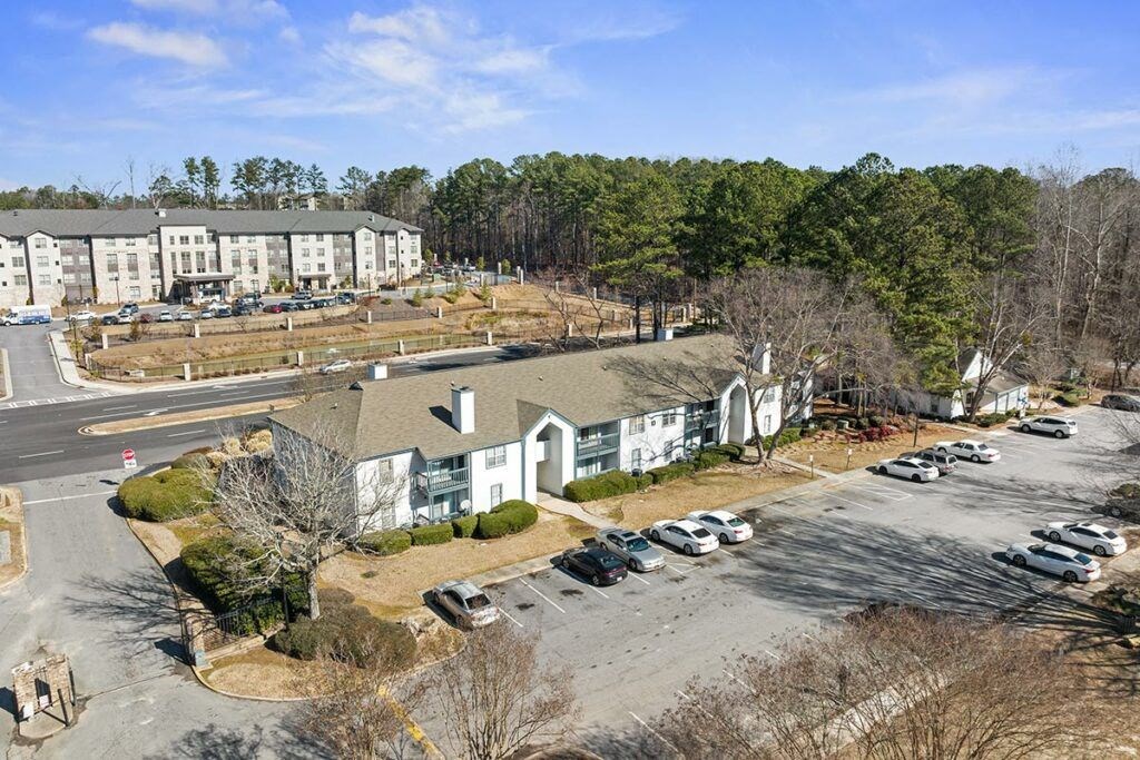 an aerial view of houses and cars parked in a parking lot