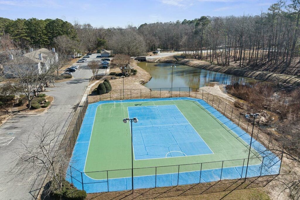 an aerial view of a blue and green tennis court    and a river
