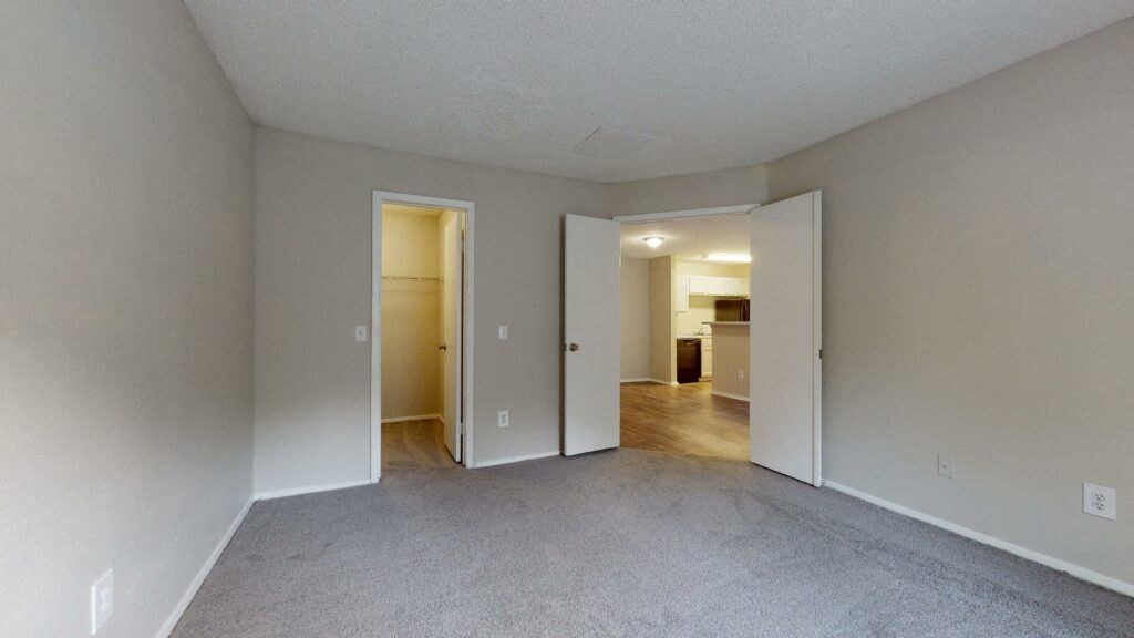 the spacious living room and dining room of an apartment