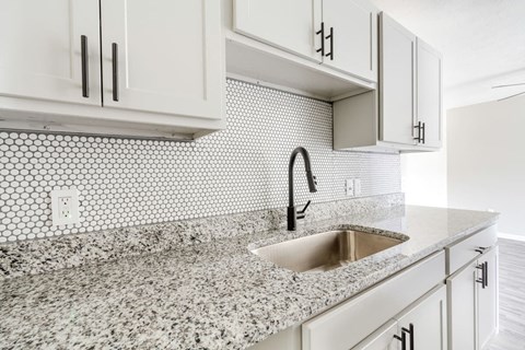 a white kitchen with white cabinets and a sink