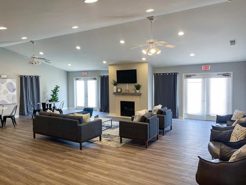 A spacious living room with a fireplace and a ceiling fan.