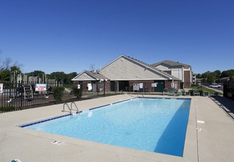 a swimming pool with a house in the background