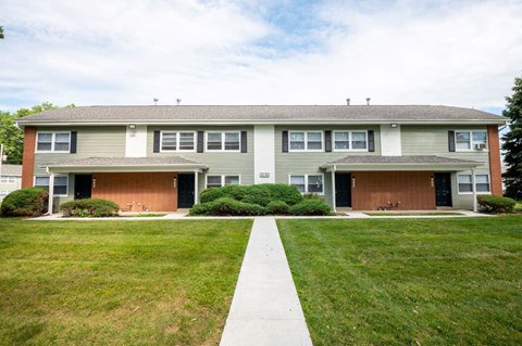 a house with a lawn and a sidewalk in front of it