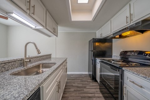 A kitchen with granite countertops and stainless steel appliances.