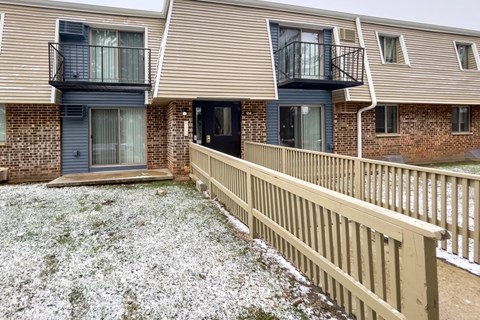 a balcony with a wooden fence in front of a brick house