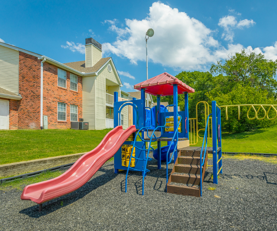 a playground with a red slide and a blue and red slide