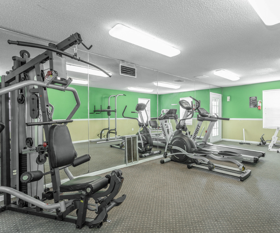 a gym with exercise equipment and mirrors in a building