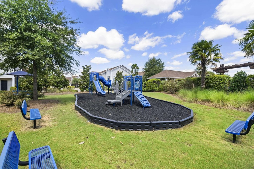 a playground with blue chairs and a black trampoline at Century HomePlace, Prattville