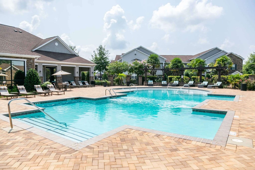 a large swimming pool with chairs around it in front of a house at Century HomePlace, Alabama