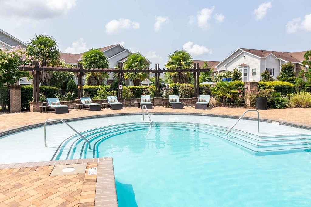 a swimming pool with chairs around it and a house in the background at Century HomePlace, Alabama, 36066